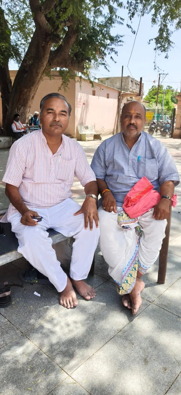 Shri Alkeshbhai Dave (left) and Shri Hiteshbhai Pandya (right), tirth purohits of Matrugaya Tirth, seated outdoors in Siddhpur
